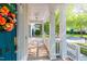 Charming front porch with white columns, railings, and a vibrant floral wreath adorning the inviting blue front door at 116 Hamilton Hedge Pl, Cary, NC 27519