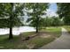 Picturesque lake view with a paved path, natural shoreline, and lush greenery at 116 Hamilton Hedge Pl, Cary, NC 27519