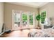 Bright bedroom with doors to outside area, large windows, and hardwood floors at 116 Hamilton Hedge Pl, Cary, NC 27519