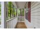 Inviting front porch with wooden deck, white railing and view of the wooded lot at 118 Setter Pt, Clayton, NC 27520