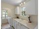 Practical kitchen showcasing white cabinets and appliances with view into a laundry room at 118 Setter Pt, Clayton, NC 27520