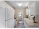 Charming kitchen featuring white appliances, cabinets, and a view to the laundry area at 118 Setter Pt, Clayton, NC 27520