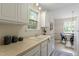 Cozy kitchen with white cabinets, neutral paint, and a view into the dining area at 118 Setter Pt, Clayton, NC 27520