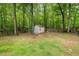 View of a storage shed in the backyard, surrounded by trees and well maintained lawn at 1205 Elysian Way, Rougemont, NC 27572