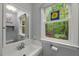 Well-lit bathroom featuring a modern vanity with view of the wooded landscape outside the window at 1205 Elysian Way, Rougemont, NC 27572