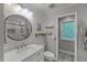 Well-lit bathroom with white vanity, round mirror, patterned floor, and glass-enclosed shower at 1205 Elysian Way, Rougemont, NC 27572