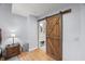 Bedroom showcasing a wooden sliding barn door leading into an updated bathroom at 1205 Elysian Way, Rougemont, NC 27572