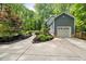 Long driveway leading to a two-car garage, lush green lawn, and mature trees at 1205 Elysian Way, Rougemont, NC 27572