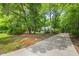 Long concrete driveway leading to a two-story home, surrounded by mature trees at 1205 Elysian Way, Rougemont, NC 27572