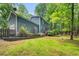 A two-story home with blue siding and a two-car garage surrounded by mature trees at 1205 Elysian Way, Rougemont, NC 27572