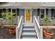 Entrance to house featuring a yellow front door with potted plants on either side of staircase at 1205 Elysian Way, Rougemont, NC 27572