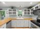 Kitchen features white cabinets, butcher block countertop, window with sink and stainless steel dishwasher at 1205 Elysian Way, Rougemont, NC 27572