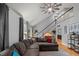 Inviting living room featuring an open staircase, hardwood floors, and comfortable sectional seating at 1205 Elysian Way, Rougemont, NC 27572