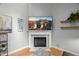 Living room featuring a fireplace with TV above, floating shelves, and hardwood floors at 1205 Elysian Way, Rougemont, NC 27572