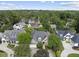 Aerial view of homes with tree coverage, landscaped lawns, gray roofs, and neighborhood street at 1210 Brooks Ave, Raleigh, NC 27607