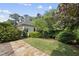 Secluded backyard with stone patio, lush lawn, mature landscaping, and detached garage at 1210 Brooks Ave, Raleigh, NC 27607