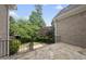 Stone patio overlooking a beautifully landscaped backyard with mature trees and wrought iron railing at 1210 Brooks Ave, Raleigh, NC 27607