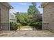 Flagstone patio and wrought iron fence with a view of the well manicured backyard and the surrounding mature trees at 1210 Brooks Ave, Raleigh, NC 27607