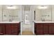 Dual vanities with cherry cabinets and marble countertops in a spacious bathroom at 1210 Brooks Ave, Raleigh, NC 27607