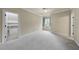 Bright bedroom with plush carpet, a window with blue drapes, and access to a walk-in closet at 1210 Brooks Ave, Raleigh, NC 27607