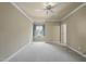 Well-lit bedroom with a ceiling fan, soft carpet, and a large window offering pleasant views at 1210 Brooks Ave, Raleigh, NC 27607