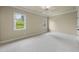 Sunlit bedroom showcasing neutral colors, plush carpet, a ceiling fan, and large windows at 1210 Brooks Ave, Raleigh, NC 27607