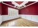 Dining room with hardwood floors, white trim, a red accent wall, wainscoting and a chandelier at 1210 Brooks Ave, Raleigh, NC 27607