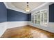 Dining area with hardwood floors, blue accent wall, wainscoting, white trim and large window with plantation shutters at 1210 Brooks Ave, Raleigh, NC 27607