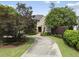 Brick home with a curved driveway, surrounded by mature trees and manicured landscaping providing great curb appeal at 1210 Brooks Ave, Raleigh, NC 27607
