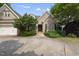 Well-kept brick home with a side entry garage, featuring a stone walkway and nicely maintained landscaping at 1210 Brooks Ave, Raleigh, NC 27607