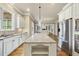 Bright eat-in kitchen features stainless steel appliances, granite countertops, and center island, with natural light at 1210 Brooks Ave, Raleigh, NC 27607