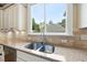 Close-up of a stainless steel kitchen sink with granite countertops and a window view at 1210 Brooks Ave, Raleigh, NC 27607