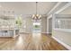 Bright living area with hardwood floors and an open layout featuring a kitchen and entryways to other rooms at 1210 Brooks Ave, Raleigh, NC 27607