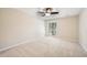 Cozy bedroom with plush carpet, ceiling fan, and window with view of trees and natural light at 124 Twin Oaks Pl, Cary, NC 27511