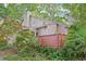 View of the home's exterior, featuring a deck and attractive landscaping with mature trees at 124 Twin Oaks Pl, Cary, NC 27511