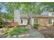 Charming home featuring a brick accent, chimney, and inviting front entrance surrounded by mature trees at 124 Twin Oaks Pl, Cary, NC 27511