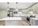 Modern kitchen features stainless appliances, kitchen island, quartz countertops, and subway tile backsplash at 124 Twin Oaks Pl, Cary, NC 27511