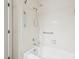 White tiled bathtub and shower with grab bars and chrome fixtures at 124 Twin Oaks Pl, Cary, NC 27511