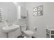 Bright white bathroom with sink, toilet, cabinet storage and decorative mirror art at 13 Toplanders Ter, Gibsonville, NC 27249