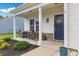 Inviting front porch with comfortable seating, decorative plants, and a charming welcome sign on the door at 13 Toplanders Ter, Gibsonville, NC 27249