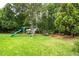 Spacious backyard features a swing set, slide, trampoline, and lush green grass for outdoor fun at 1428 White Opal Dr, Knightdale, NC 27545