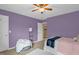 Serene bedroom with a soft beanbag chair, plush bed, and soothing purple walls for relaxation at 1428 White Opal Dr, Knightdale, NC 27545