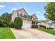 A home boasts a well-maintained lawn and driveway leading to a two-car garage, complemented by mature landscaping at 1428 White Opal Dr, Knightdale, NC 27545