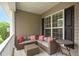 Comfortable covered porch featuring wicker seating, decorative cushions, and a side table, perfect for relaxing at 1428 White Opal Dr, Knightdale, NC 27545