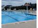 Community swimming pool with blue water, lane lines, sun umbrella and chairs with neighborhood homes in the background at 1428 White Opal Dr, Knightdale, NC 27545