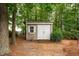 Charming backyard shed with white doors and a window, nestled among lush trees for extra storage at 1428 White Opal Dr, Knightdale, NC 27545