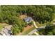 Aerial view of home nestled among mature trees, with a long driveway and large yard at 147 Gentry Dr, Pittsboro, NC 27312