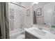 Well-lit bathroom featuring a bathtub with tiled walls, a modern vanity, and a stylish mirror at 147 Gentry Dr, Pittsboro, NC 27312