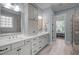 Modern bathroom featuring dual sinks, quartz countertops, and access to a walk-in closet at 147 Gentry Dr, Pittsboro, NC 27312