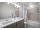 Well-lit bathroom with double sink vanity, a large mirror, and a shower-tub combo with tiled walls at 147 Gentry Dr, Pittsboro, NC 27312